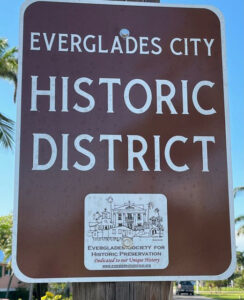 A brown, outdoor sign says "Everglades City Historic District"