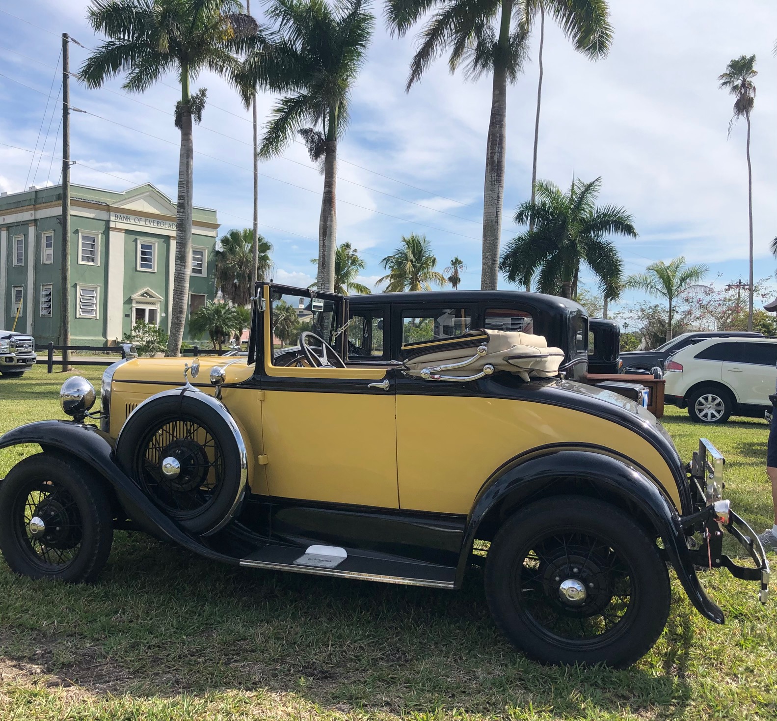 A vintage car parks outside the Bank of Everglades.